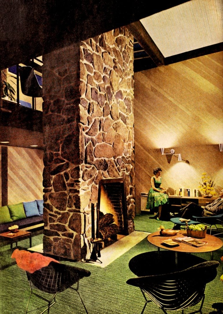 Retro lake view home two-sided stone fireplace living room