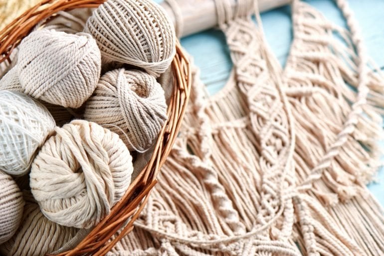 Handmade macrame braiding, background thread on a wooden Board top view